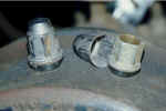 Original lug nuts. Whole nut on the left, tin cap in the center, bare nut on the right.